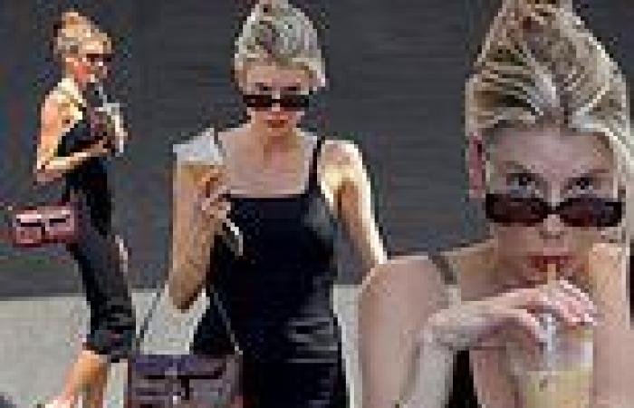 Charlotte McKinney dazzles in a form-fitting black knit sundress as she waits ...