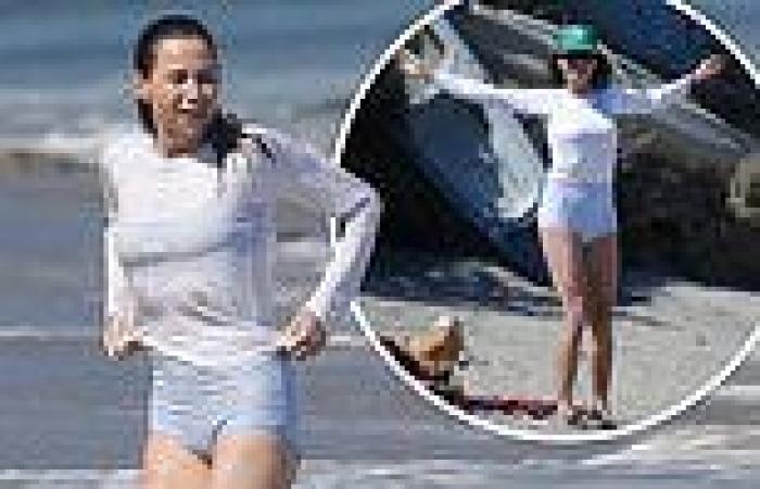 Minnie Driver showcases her toned legs in blue swimming bottoms as she enjoys ...