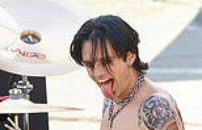 Sebastian Stan sticks out his long tongue while drumming in leather shorts on ...