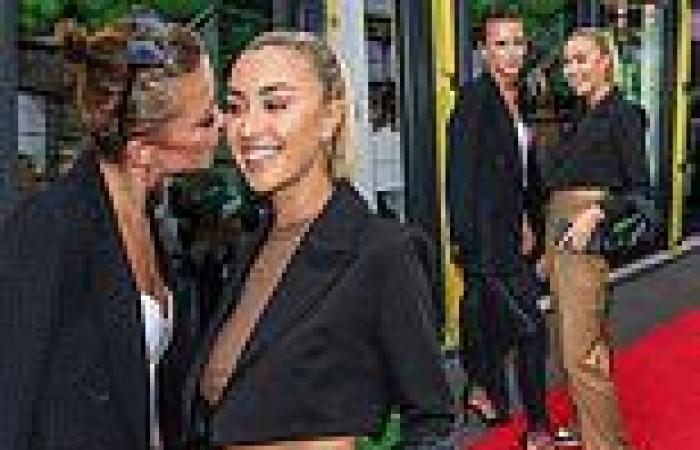 MIC's Olivia Bentley plants a kiss on pal Sophie Habboo as they lark around at ...