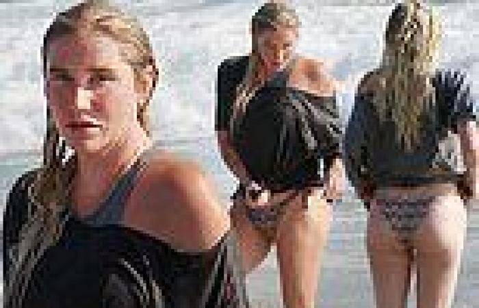 Kesha takes a dip in the ocean wearing bikini bottoms and a black top