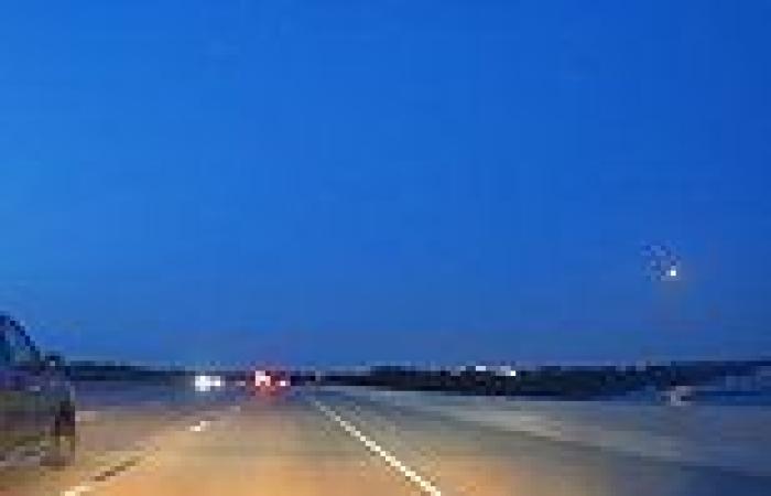 Fiery meteor streaks across the sky above a Texas highway