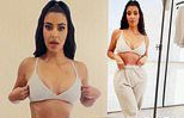 Kim Kardashian shows off her toned tummy as she poses in a bra