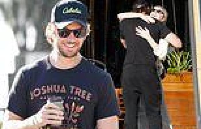 Sex/Life star Adam Demos covers up in baggy sweatpants as he hugs a friend on ...
