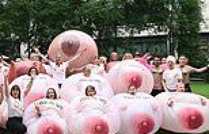 Dozens of medical tattooists dress as giant inflatable BREASTS outside Facebook ...