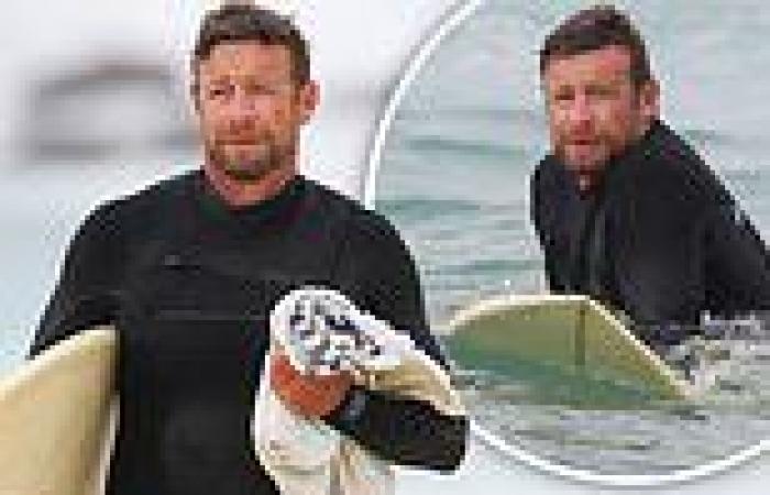 Simon Baker slips into a wetsuit and hits the beach for a surfing session with ...