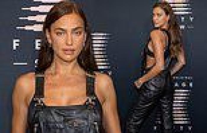 Irina Shayk wears only a bra under her leather overalls as she attends ...