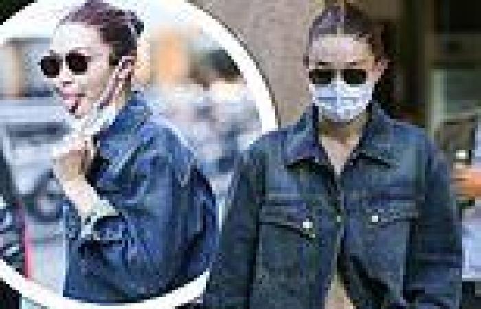 Gigi Hadid flashes her taut midriff in a chic denim jacket while signing ...