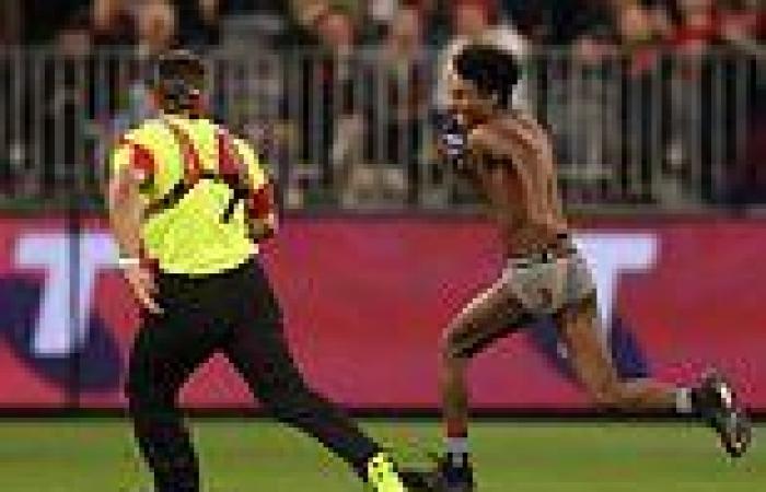 Daring pitch invader storms the field during the AFL Grand Final as Demons ...