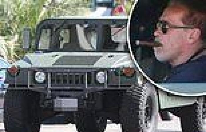 Arnold Schwarzenegger chomps on a cigar while driving his military-grade Humvee