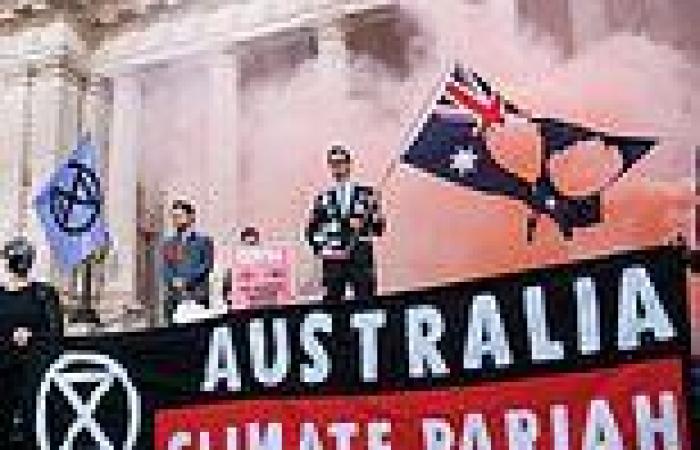 Extreme climate activists burn an Australian flag on the steps of the Victorian ...