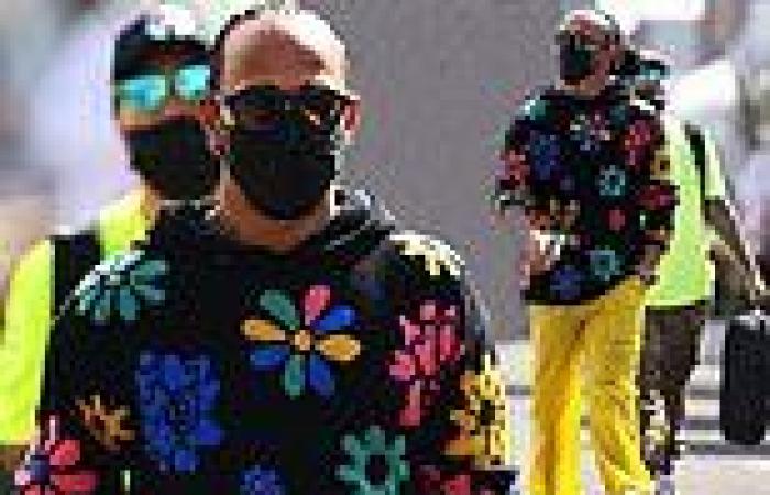 Lewis Hamilton cuts a cheerful figure in a floral jumper and bright yellow ...