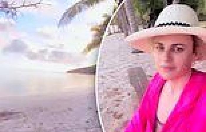 Rebel Wilson rocks a hot pink top as she wakes up to a tropical sunrise while ...