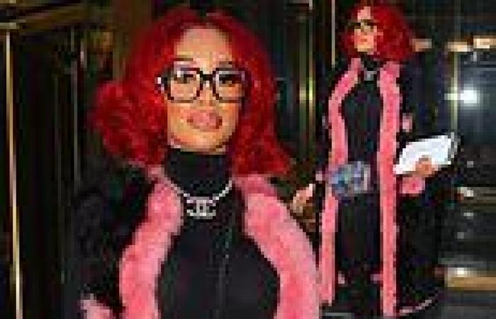 Saweetie rocks pink fur-lined coat that goes with her fiery red locks as she ...