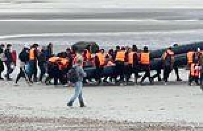 Migrants cheer and clap as they restart boat engine to cross the Channel as ...