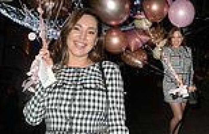 Kelly Brook carries a bundle of balloons out of Heart Radio while celebrating ...