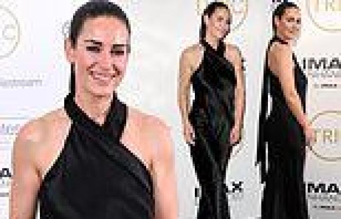 Kirsty Gallacher cuts a glamorous figure in a black halterneck jumpsuit
