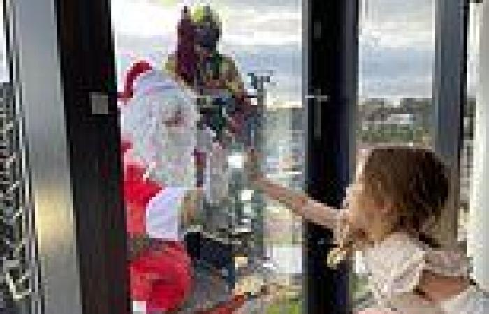 Santa swaps his sleigh for a CRANE to visit sick children in hospital