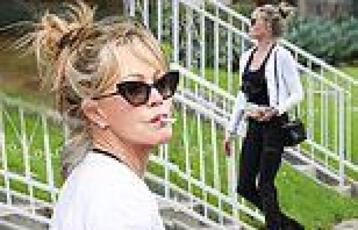 Melanie Griffith puffs on a cigarette while rocking an athletic look before ...