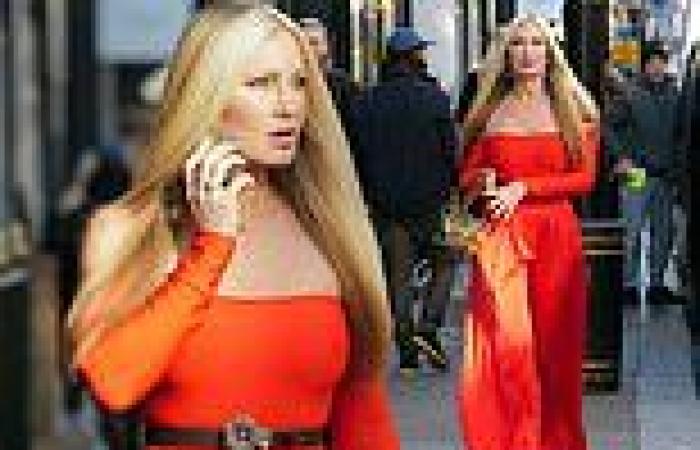 Caprice Bourret cuts a glam figure in a bardot red top and flared satin trousers trends now