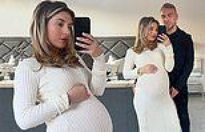 Pregnant Dani Dyer displays her growing baby bump in a clinging white maxi dress trends now