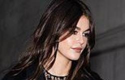 Kaia Gerber flashes her bra in a sheer black mesh top with maxi coat as she ... trends now