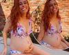 Stacey Solomon cups her burgeoning bump in a floral bikini as she enjoys a ...