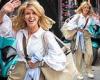 Kate Garraway cuts a relaxed figure in beige wide-leg trousers and a white ...