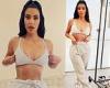 Kim Kardashian shows off her toned tummy as she poses in a bra