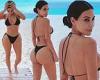 Kim Kardashian is seen in a black string bikini on the beach