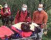Mountain rescue team stretcher stranded Labrador down off hilly terrain