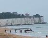 Migrants celebrate as they land on Broadstairs beach in Kent in front of ...
