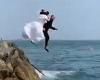 Bride and groom celebrate marriage by jumping into the Irish Sea wearing their ...