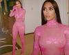 Kim Kardashian shows off her hourglass curves in a sheer lace pink bodysuit