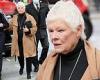 Dame Judi Dench, 86, dons a black polo-neck sweater and nude trench coat as she ...