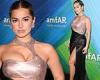 Addison Rae puts her cleavage front and center in a silky black gown at amfAR ...