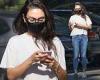 Masked Mila Kunis is glued to her cellphone while out tackling her to-do list ...