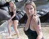 Kesha makes waves as she flashes cleavage in black bathing suit
