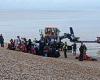 Mother clutches baby to chest as she scrambles up Kent beach after 200 migrants ...