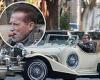 Arnold Schwarzenegger enjoys a cigar as he drives classic Excalibur vehicle in ...