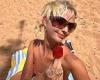 Mia Regan wears a red gingham bikini as she sunbathes on the beach in Australia  trends now